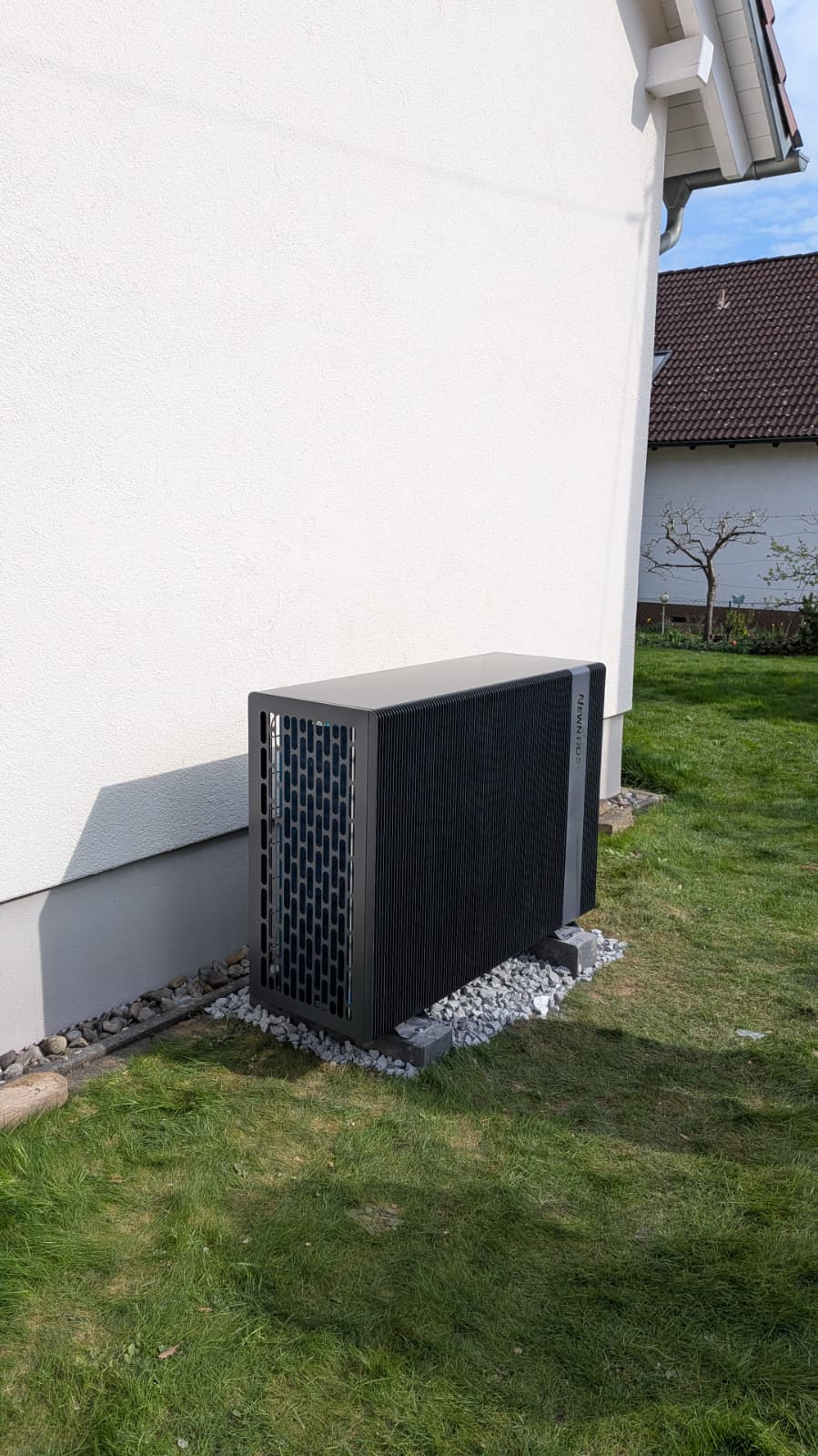 Wärmepumpe an der Hauswand mit Kiesbett