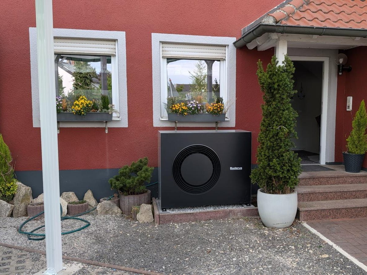Buderus-Wärmepumpe vor dem Hauseingang eines Einfamilienhauses